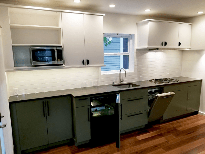 Galley kitchen with two-tone cabinets and subway tile