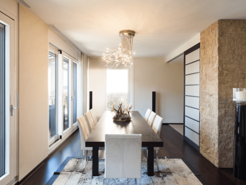 Dining room with branch chandelier, stone accent wall, and shoji screen