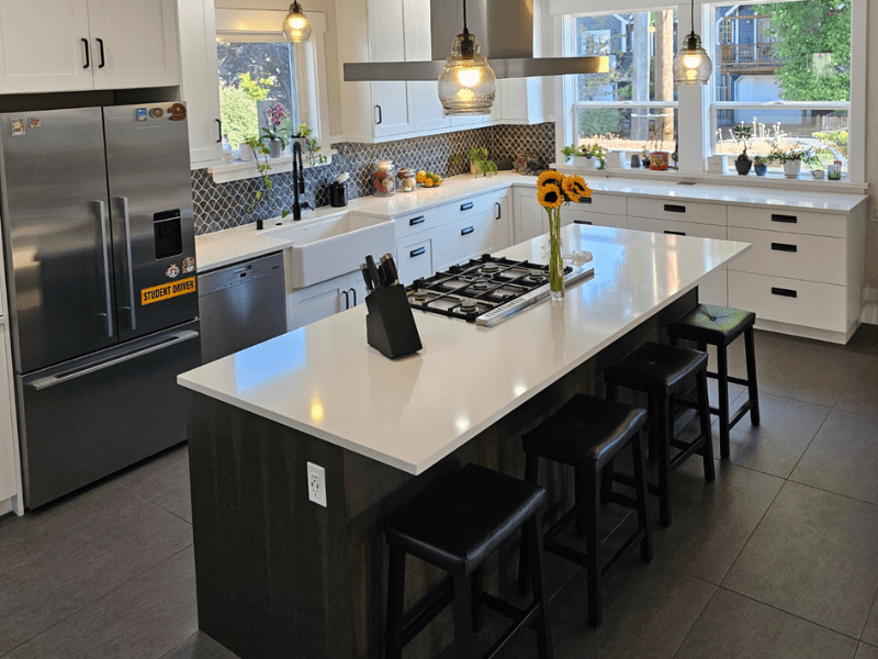 Kitchen island with gas cooktop, pendant lighting, and farmhouse sink