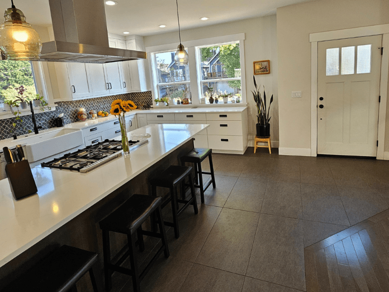 Traditional white kitchen with ornate pendants and dark island
