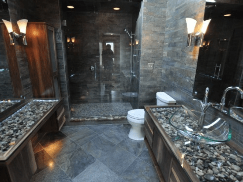 Stone-clad spa bathroom with glass vessel sink and river-rock counters