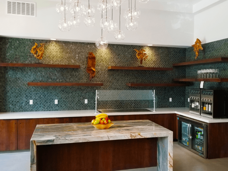 Entertainment bar with green tile wall, floating shelves, and stone island