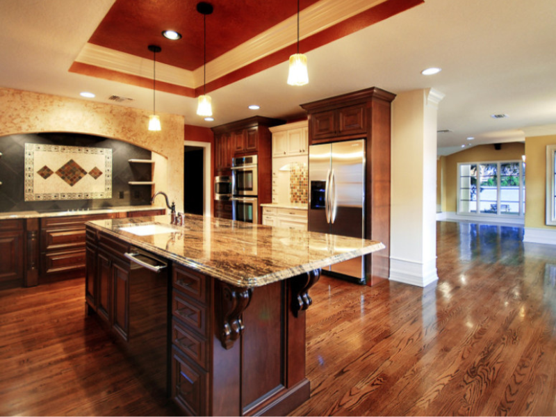 Luxury kitchen with cherry cabinetry, granite island, and coffered ceiling